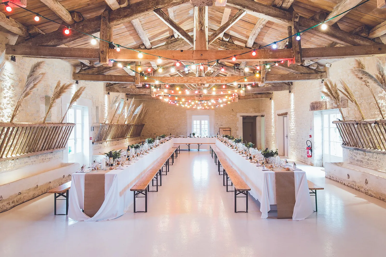 Long banquet tables set under strings of lights